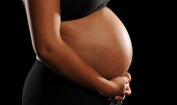 Young African American Woman Pregnant isolated on a black backgr